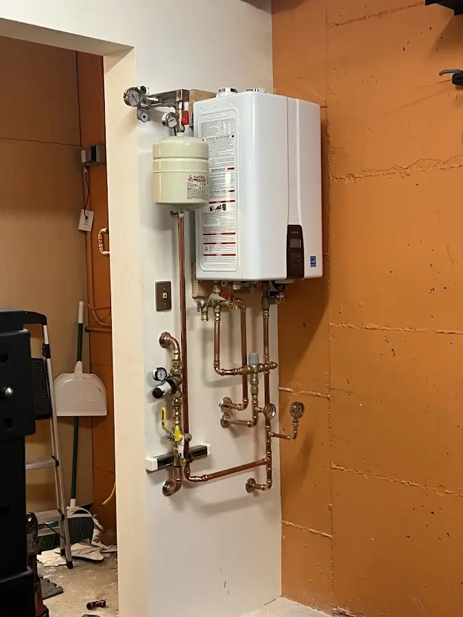 Plumbing technician inspecting water heater connections in Collingswood